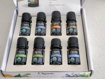 A set of eight Cliganic essential oil bottles in a box, each labeled with different scents like peppermint and lavender