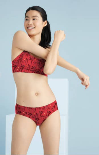 a model showing the front of the red and orange palm printed undies