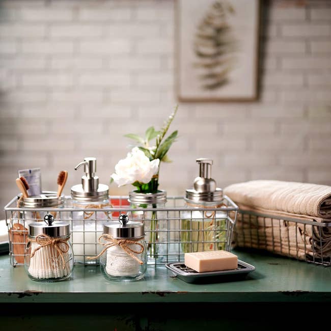 Bathroom countertop with soap dispensers, jars, a towel, and a soap bar, arranged neatly successful  a ligament  handbasket  for location  organization