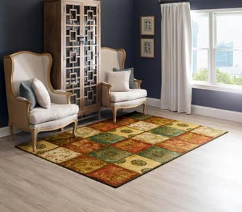 Image of the patchwork boho rug with two ivory chairs