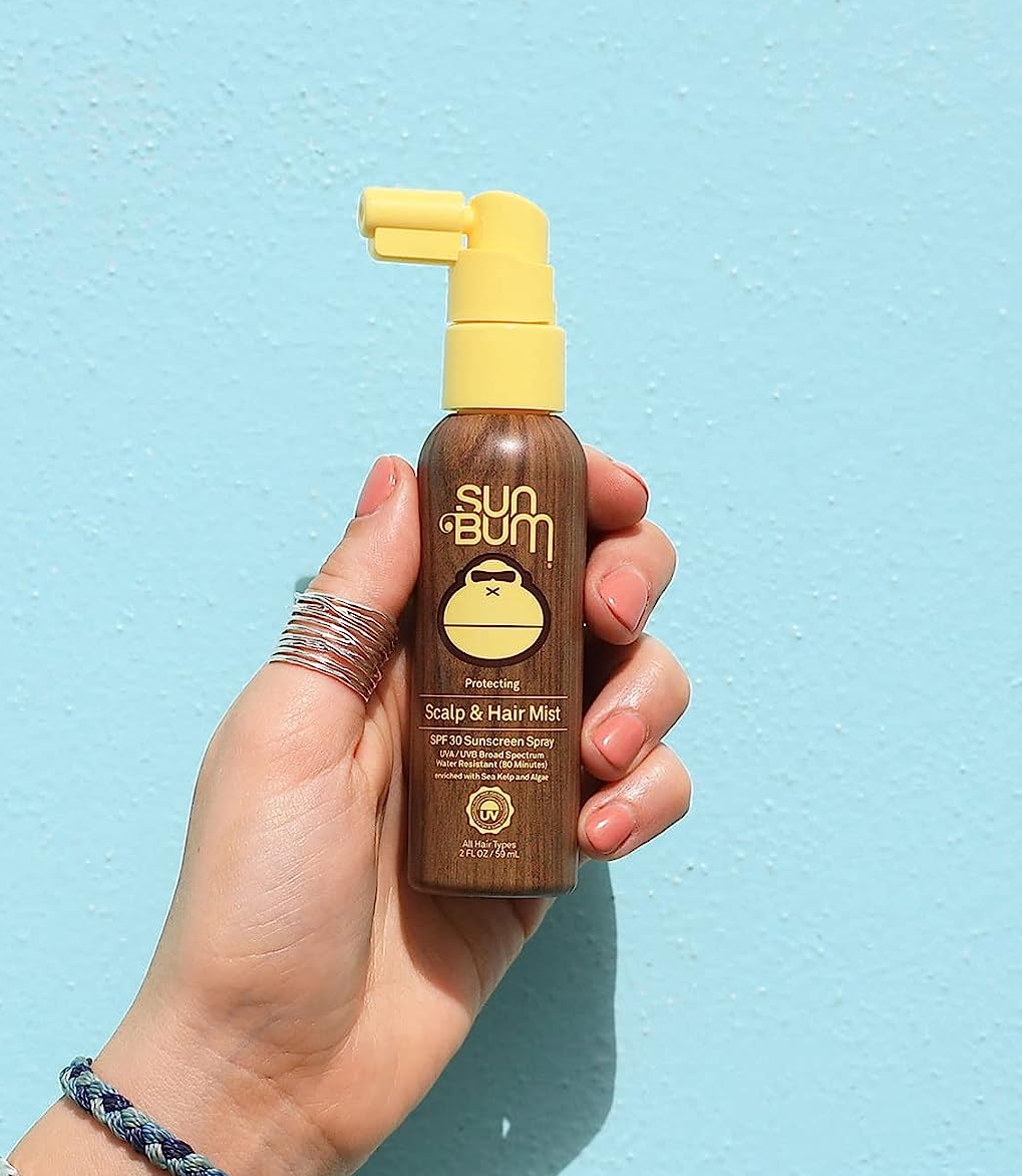 Model holding spray bottle of SPF mist