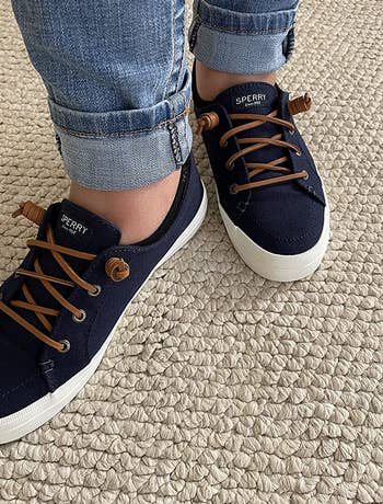 reviewer's feet in the navy sneakers