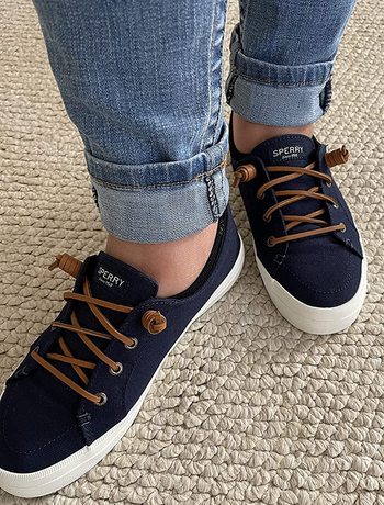 reviewer's feet in the navy sneakers