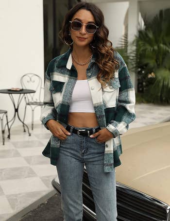 model wearing the green and white shacket over a white crop top with jeans