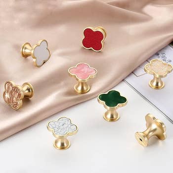 an array of gold clover-shaped knobs in different colors