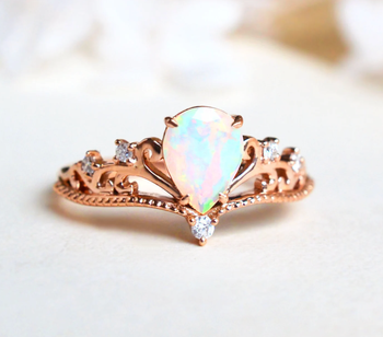 The opal ring in a pear cut with a rose gold vintage style band with swirls and small diamonds