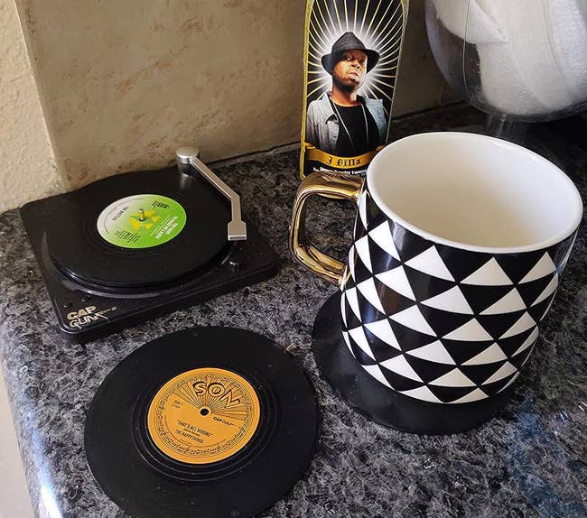 A reviewer's mug on a coaster and some coasters in the record player