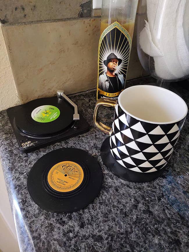 A reviewer's mug on a coaster and some coasters in the record player