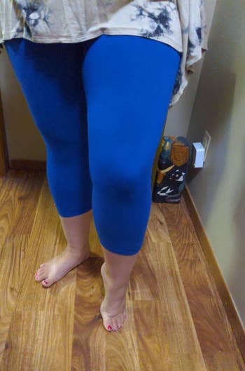 reviewer wearing blue capri length leggings