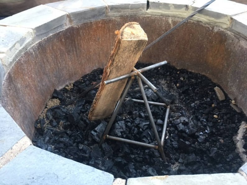 Vertical occurrence  pit log holder with charred wood   and ash wrong  a chromatic  occurrence  pit. Ideal for controlled burning and businesslike  vigor   distribution