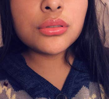 reviewer wearing the gloss on their lips in the juicy cherry color