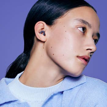 Person wearing wireless earbuds looks to the side, showcasing a sleek plan  for a buying  article