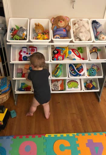 reviewer's child grabbing a toy from the easily accessible bins