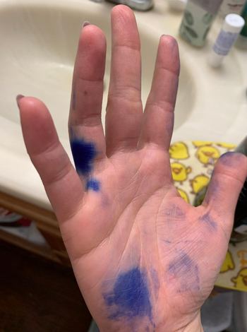 reviewer's hand with blue hair dye splotches 