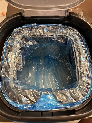 the inside of the litter genie, showing it's lined with a blue plastic liner