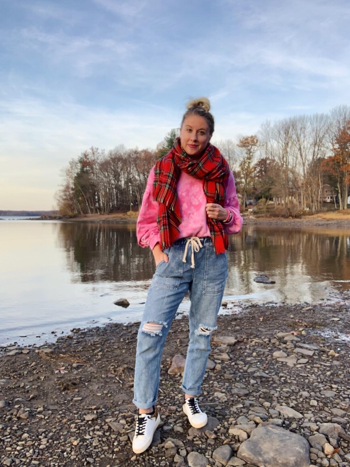 reviewer wearing the distressed jean joggers outside with a scarf