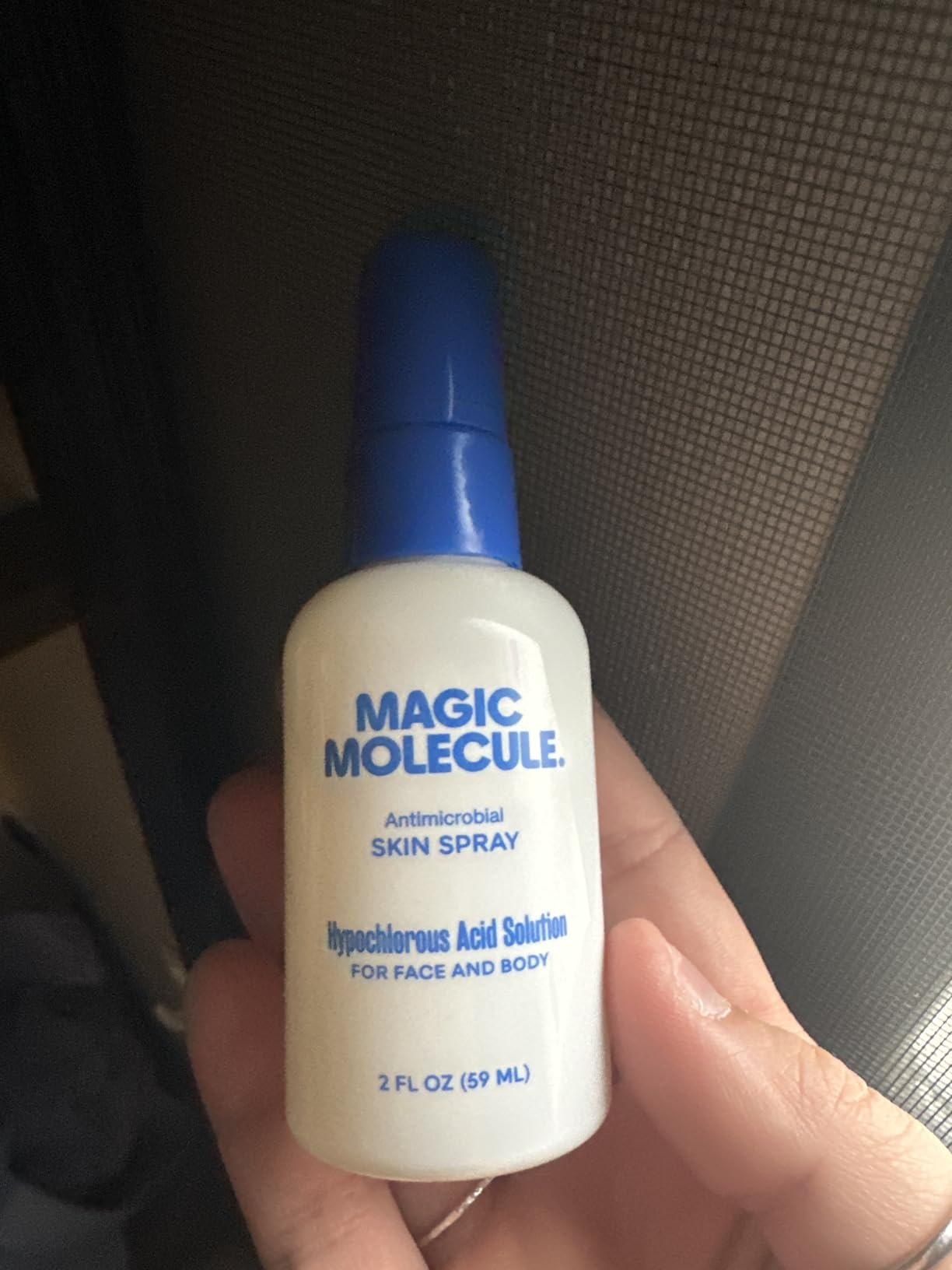A manus  holds a 2 fl oz vessel  of 