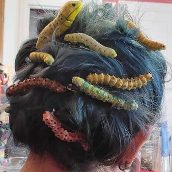 Person with styled hairsbreadth featuring decorative, realistic caterpillar hairpins, creating a unsocial and playful look