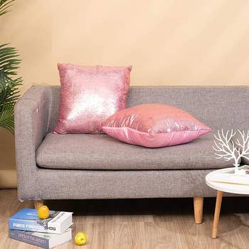 The pink pillows on a grey couch