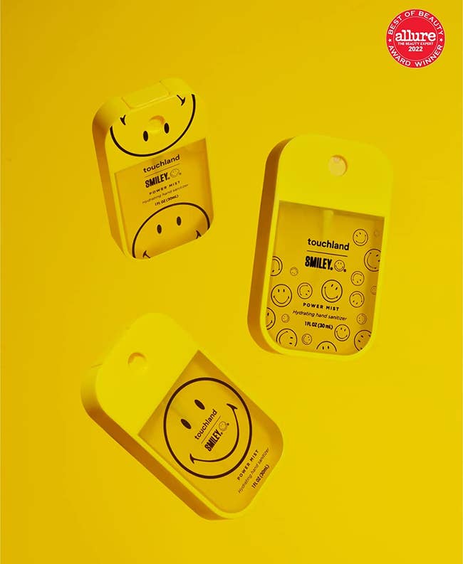 three yellow smiley face adorned touchland hand sanitizers