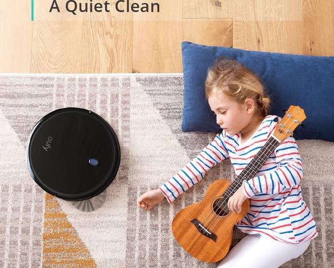 the robot vacuum next to a sleeping child