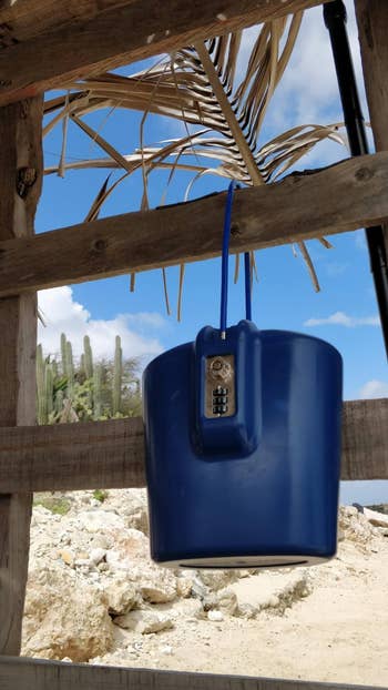 reviewer's blue portable safe locked on a cabana