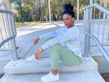 reviewer in the white puma sneakers styled with green joggers and a tie-dye long sleeve tee