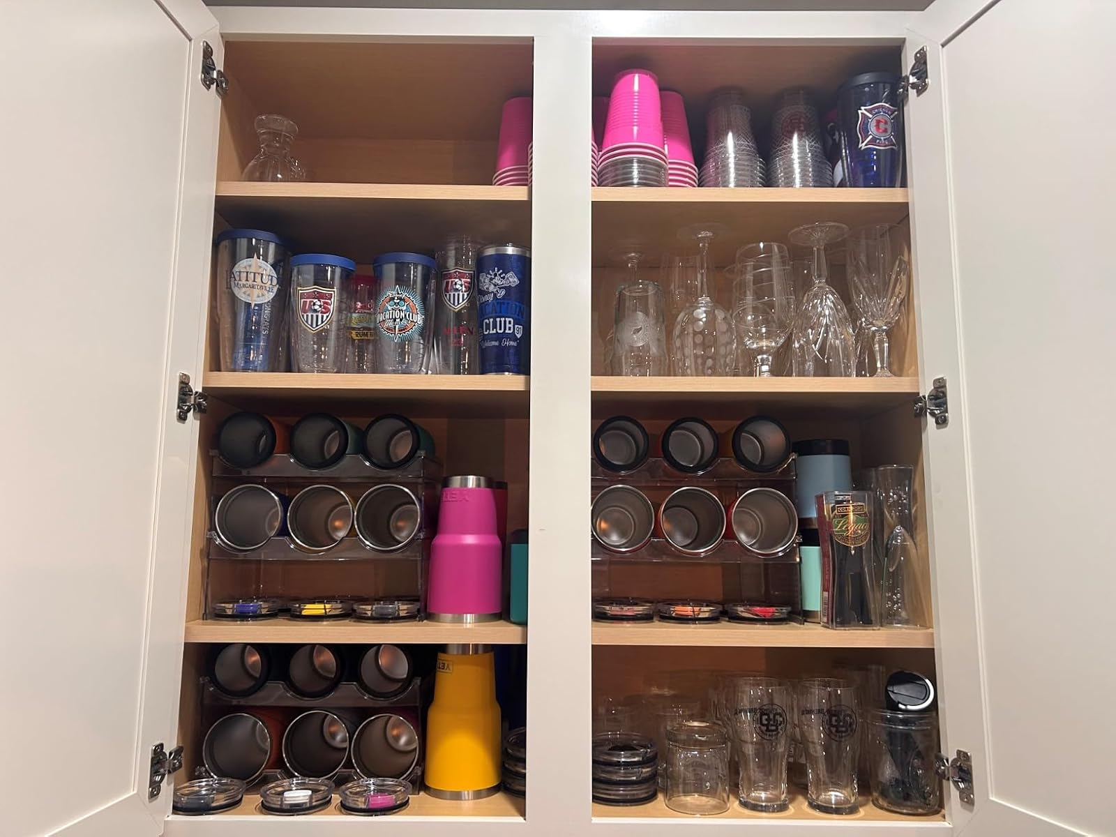 Organized room  cupboard holding assorted  tumblers and lids