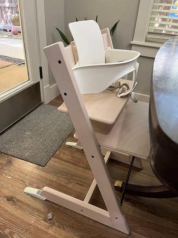 A modern high chair with a sleek design, displayed in a boutique-like setting for shopping purposes