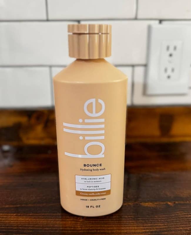 Bottle of Billie Bounce hydrating assemblage  lavation  connected  a woody  surface