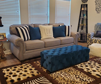 a reviewer photo of the couch with the ottoman sitting in front of it as a coffee table 