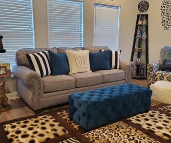 a reviewer photo of the couch with the ottoman sitting in front of it as a coffee table 
