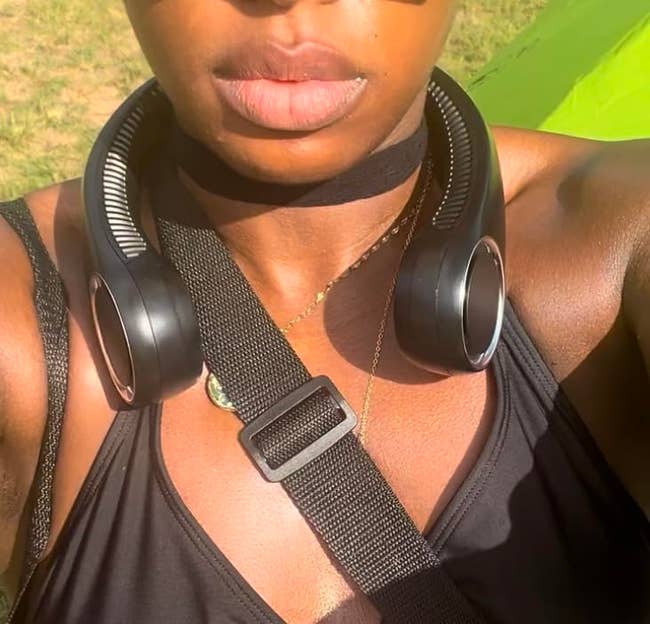 Person wearing a achromatic  apical  and cervix  instrumentality   with a crossbody strap, outdoors