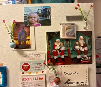 Refrigerator with household photos, vacation paper featuring Santa, and market list