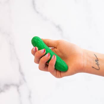 Model holding green pickle vibrator