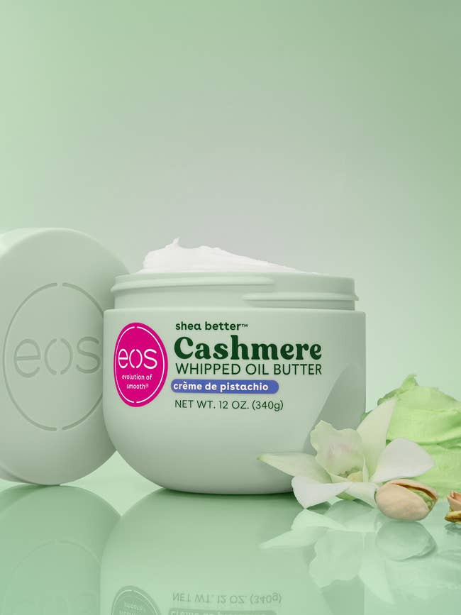 A jar of EOS Cashmere Whipped Oil Butter with shea, surrounded by flowers, utilized for a buying article