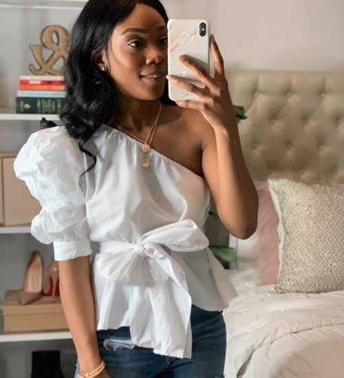 reviewer wearing the top in white with blue jeans