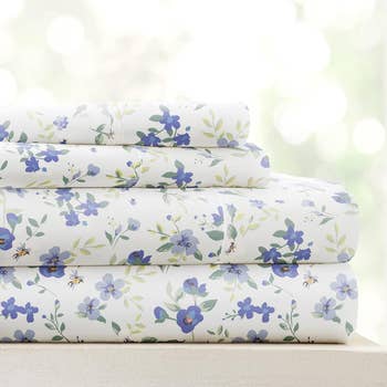 A neatly stacked set of floral patterned sheets