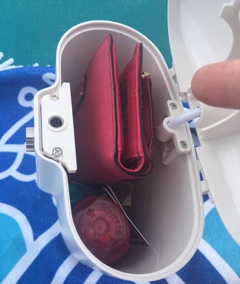 a reviewer photo of an open safe with a wallet inside 