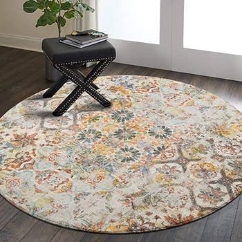 the round abstract floral area rug with a stool on it