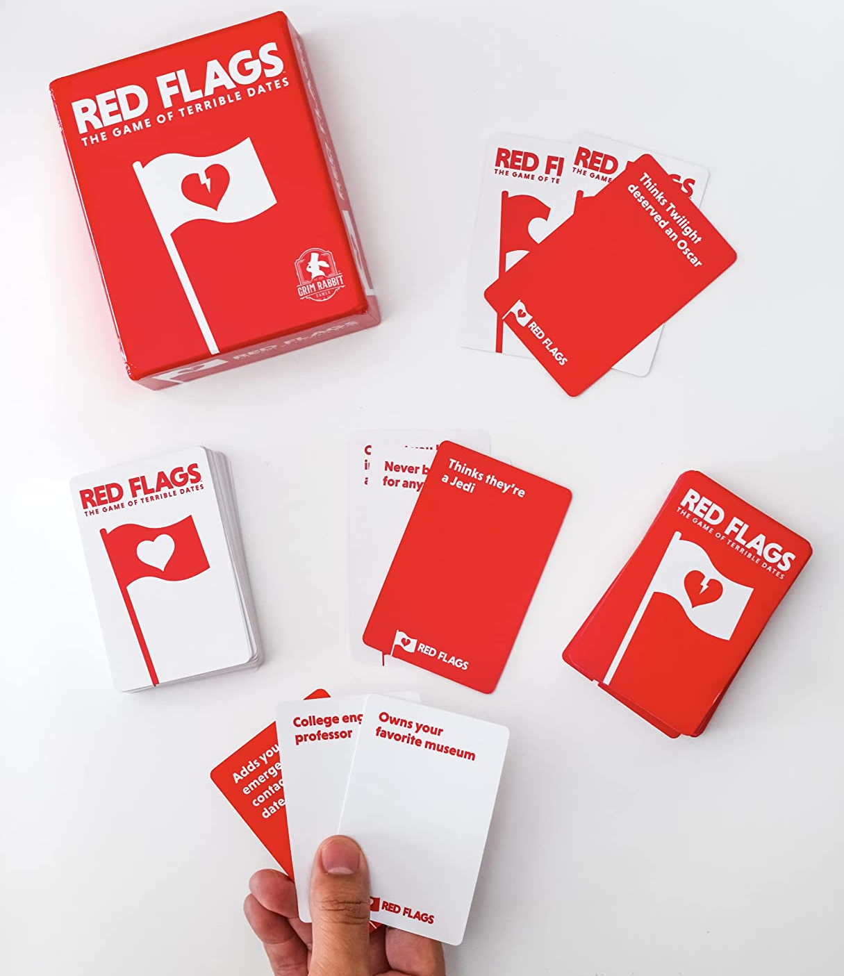 a model holding a hand of cards, two card deck, and the game box