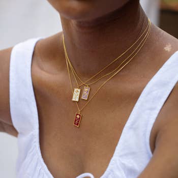 a model wearing three birth flower pendant necklaces