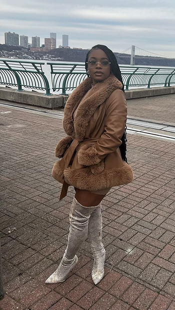 reviewer posing in brown coat