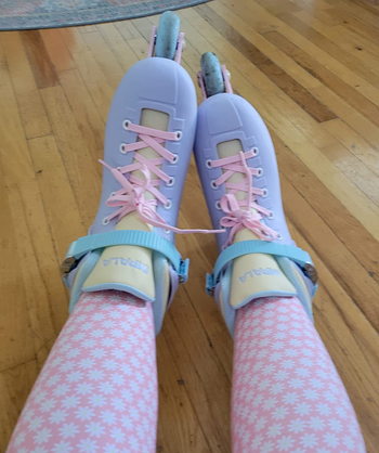 Reviewer wearing blue and pink skates with pink leggings