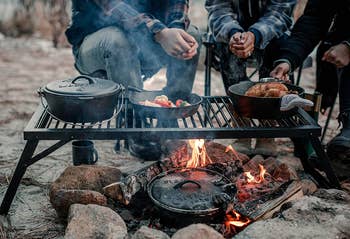 people using cast iron cook set to cook over campfire