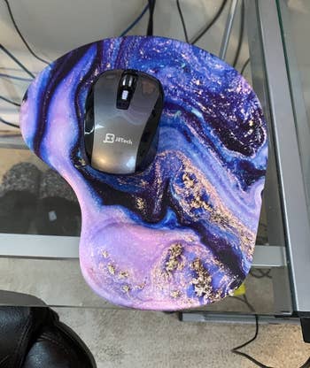 reviewer photo of mouse on a blue and purple marbled mouse pad with wrist support