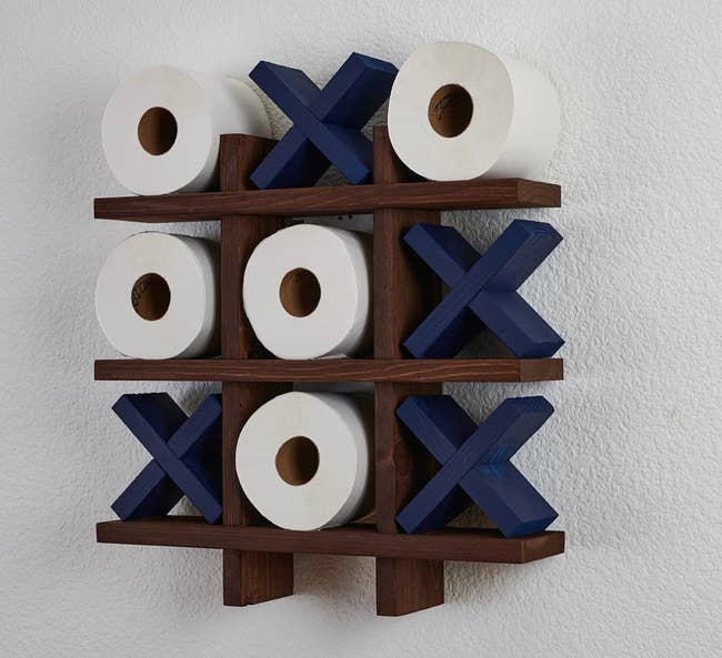 navy blue tic tac toilet roll holder mounted on a wall
