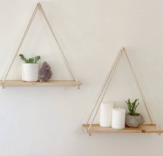two floating shelves holding candles and plants
