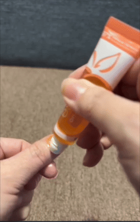 Person applying articulator  balm from a tube