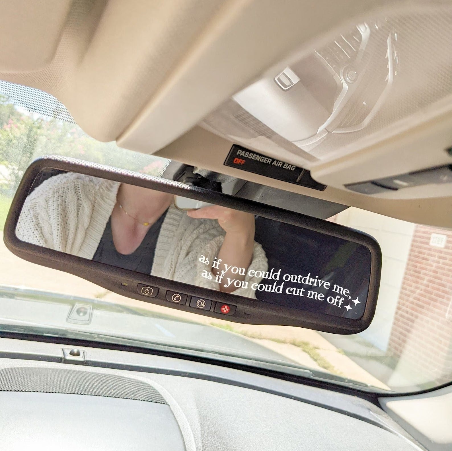 white sticker in corner of rearview mirror that says 